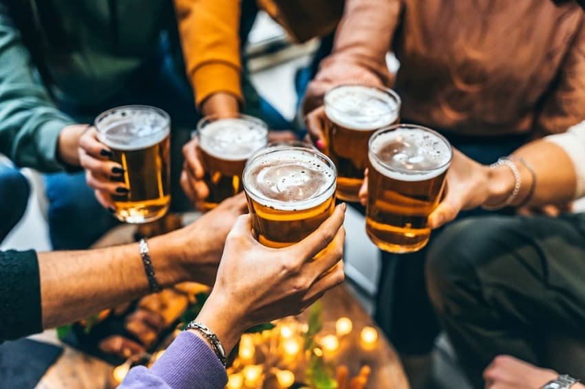 A group of people holding glasses of beer