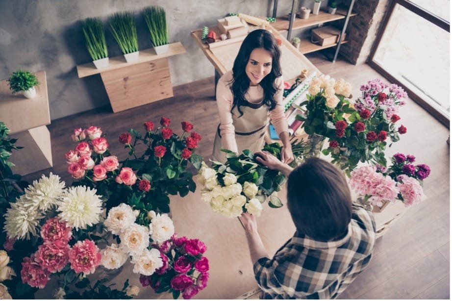 A person holding flowers in a flower shop