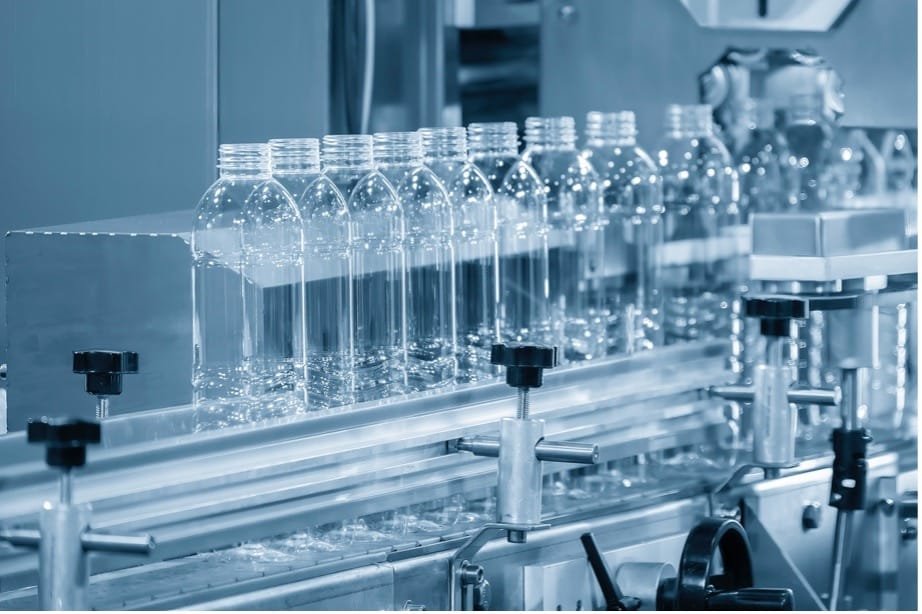 A row of clear bottles on a conveyor belt